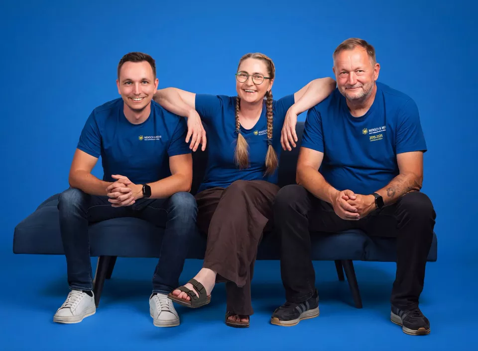 Die Geschäftsführung von MENSCH & MEHR auf einem Sofa: Philipp Isert, Jacqueline Lange und Dirk Isert (von links)