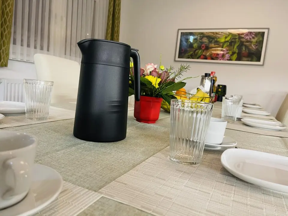 Frühstückstisch mit Kaffeekanne und Blumen