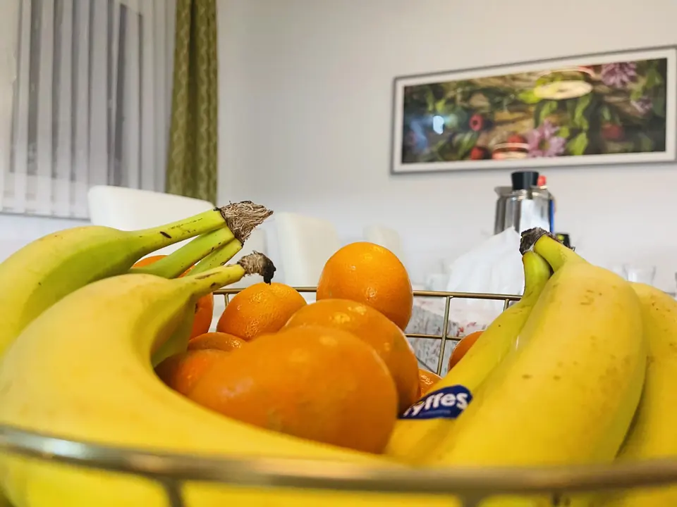 Obstschale mit Bananen und Orangen auf dem Esstisch